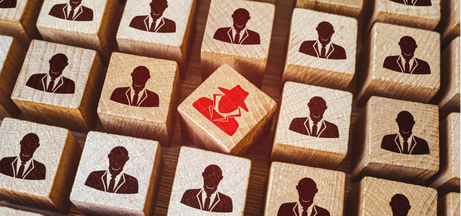 wood blocks depicting a cyber attacker among employees | What Will Happen If Your Company Suffers a Data Breach?